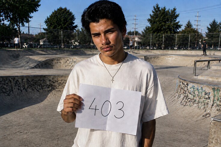 Jonathan Velasquez tenant une feuille portant le nombre 403 dans un skatepark
